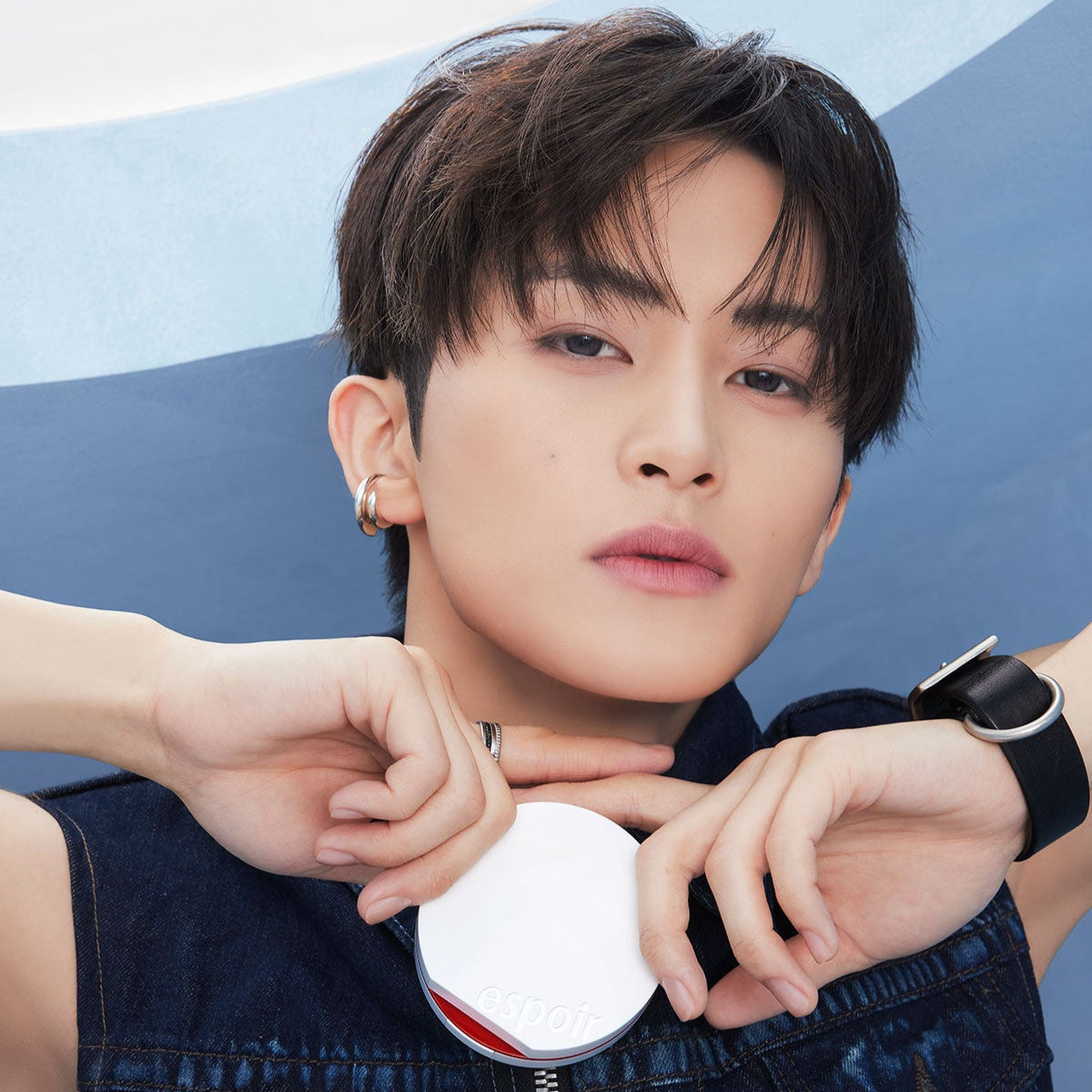 Person holding ESPOIR Bevelvet Sebumcut Cooling Cushion, showcasing sleek design and branding.