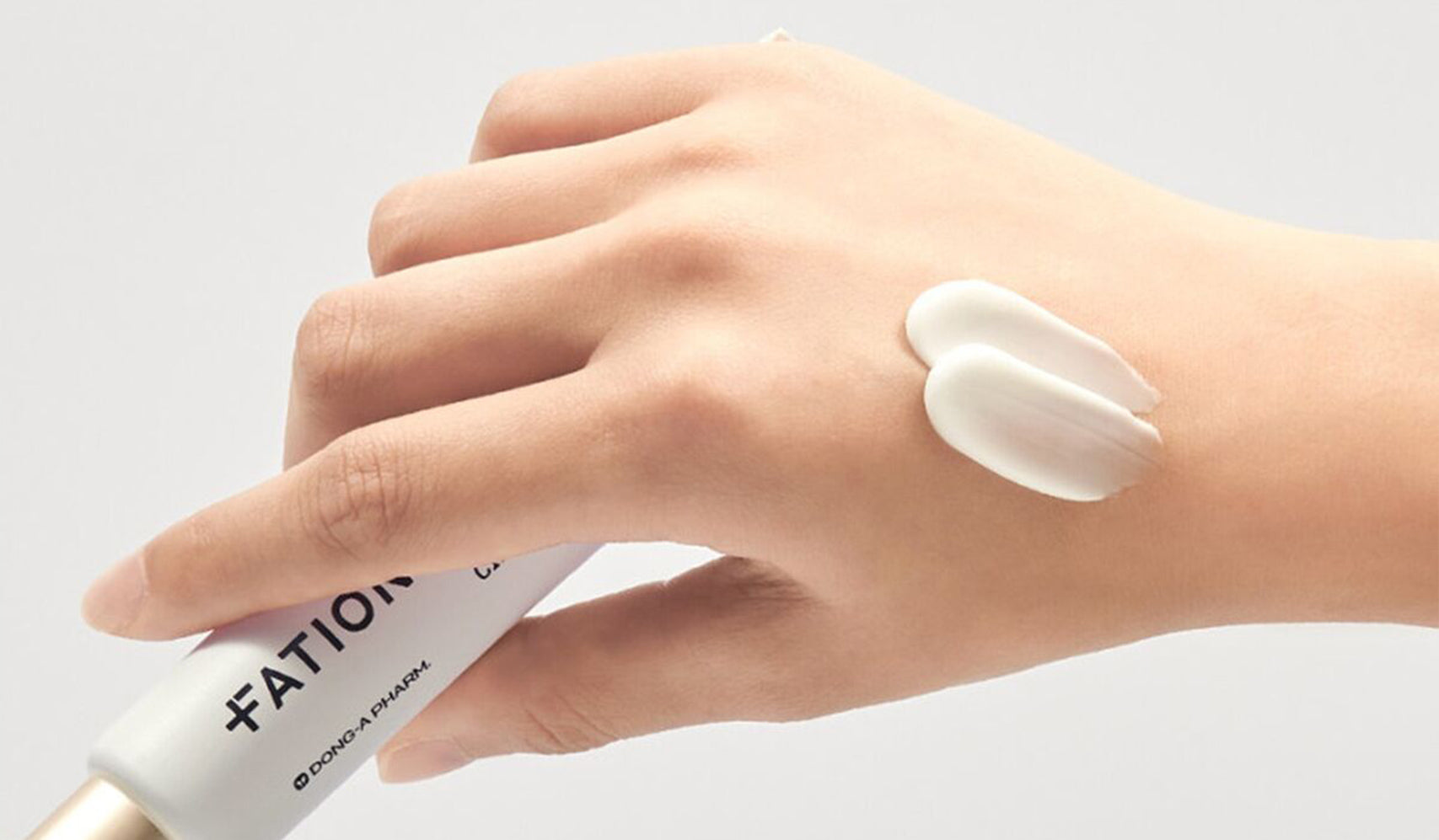 Hand applying Fation skincare cream on skin, demonstrating product texture and moisturizing effect.