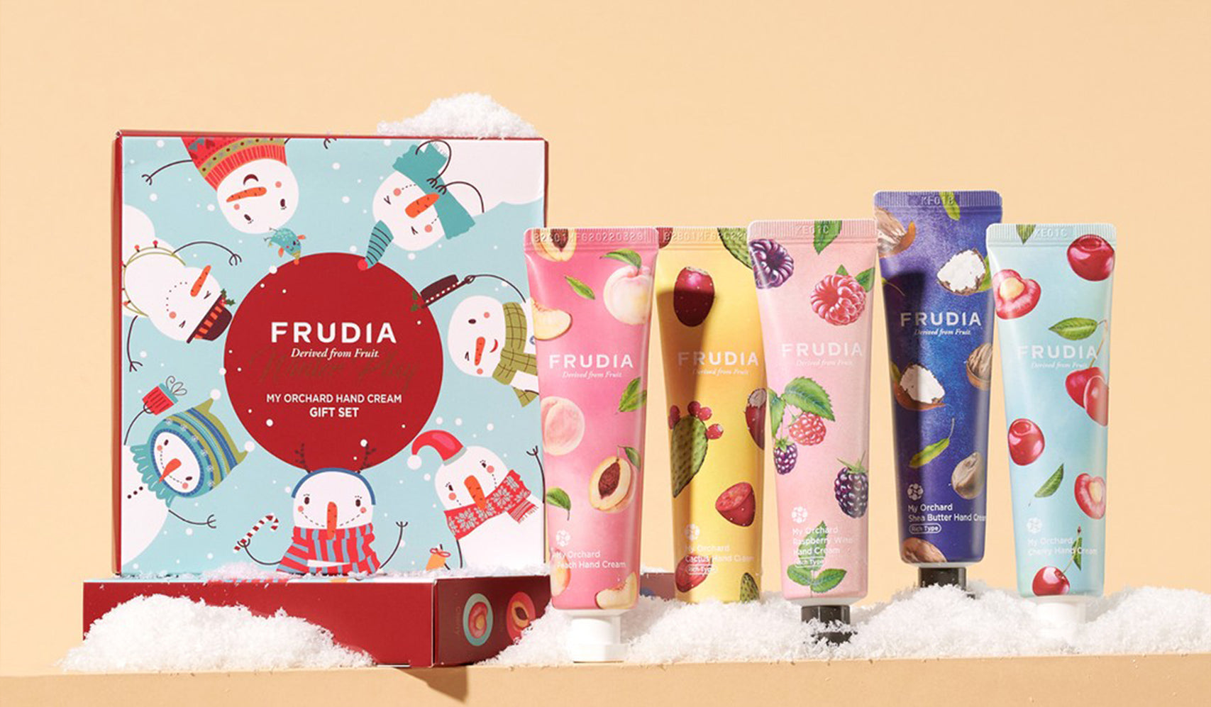 Frudia hand cream gift set with colorful fruit-themed packaging on a snowy background