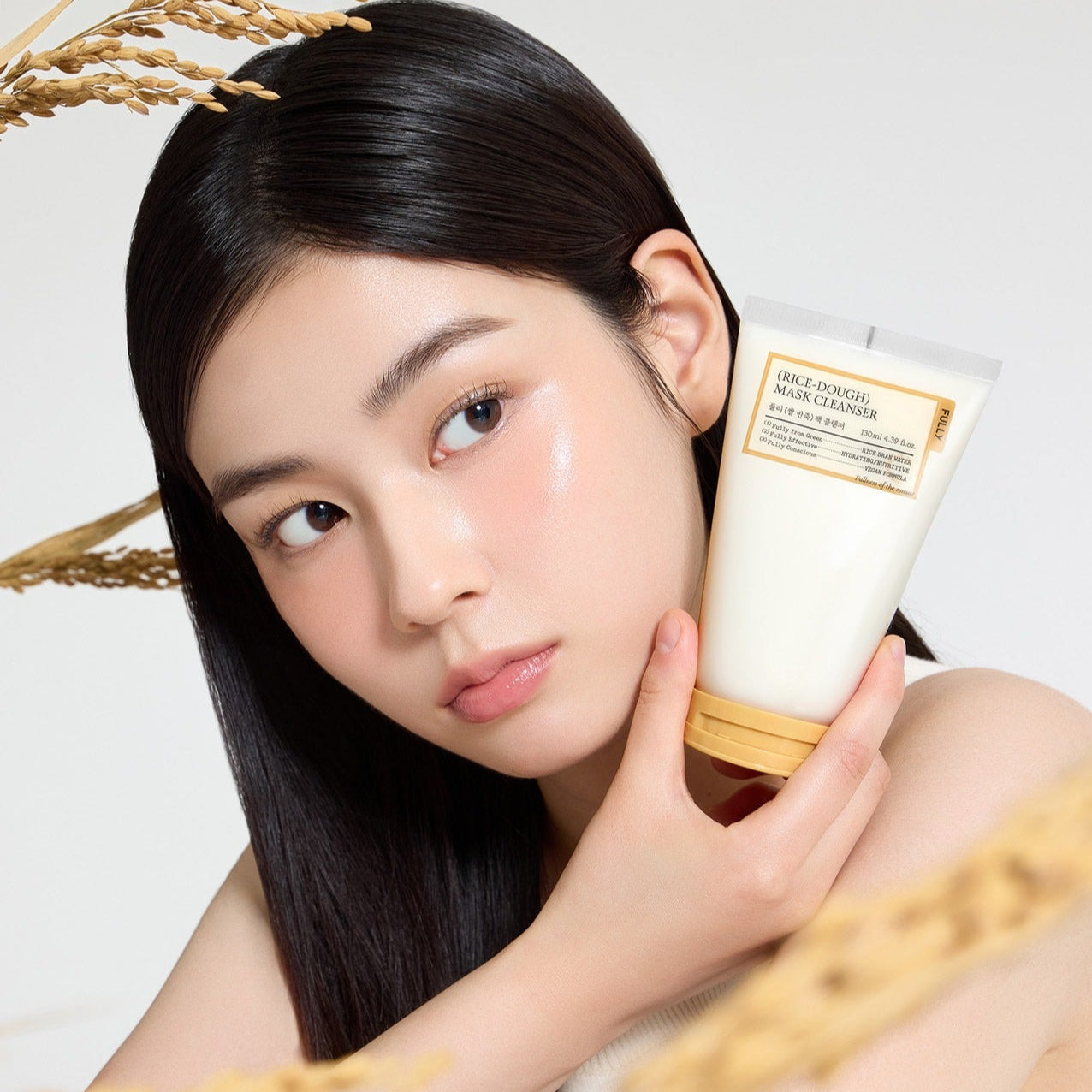 Woman holding FULLY Rice Dough Pack Cleanser 130ml bottle