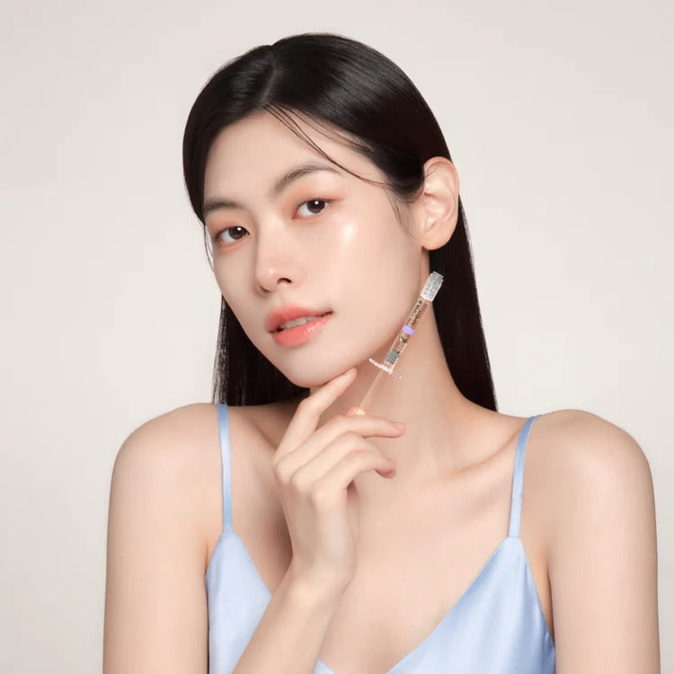 Woman holding GENABELLE Melacare Spicule Toning Shot Ampoule 3ea against her cheek, showcasing skincare product.