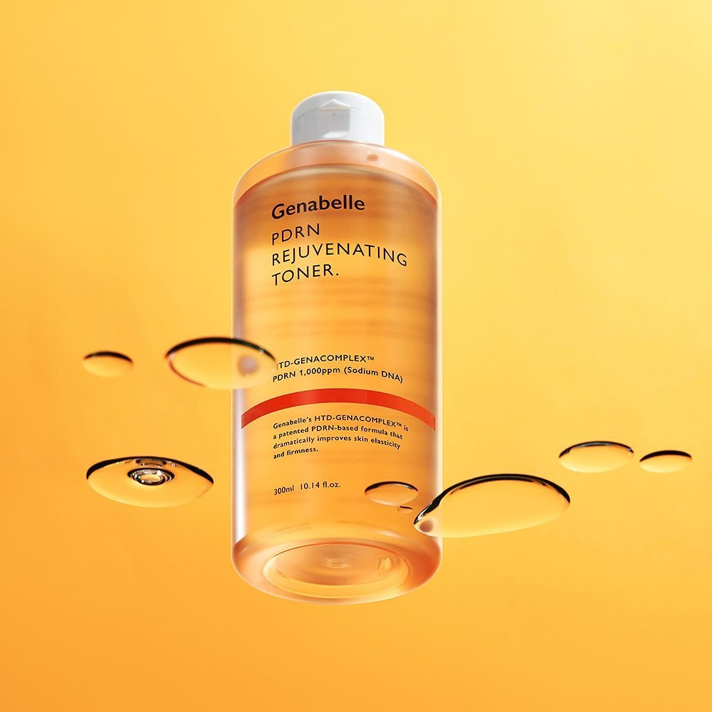 GENABELLE PDRN Rejuvenating Toner 300ml bottle against orange background with liquid droplets