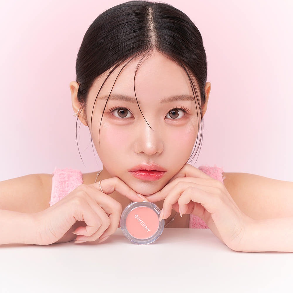 Model holding GIVERNY Dewy Gel Glow Blusher 2.7g with a pink background showcasing the cosmetic product.