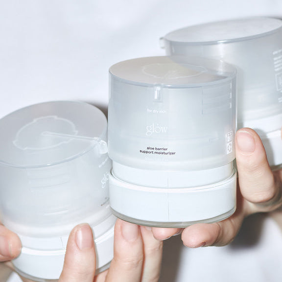 Hands holding jars of GLOW Aloe Barrier Support Cream 50ml
