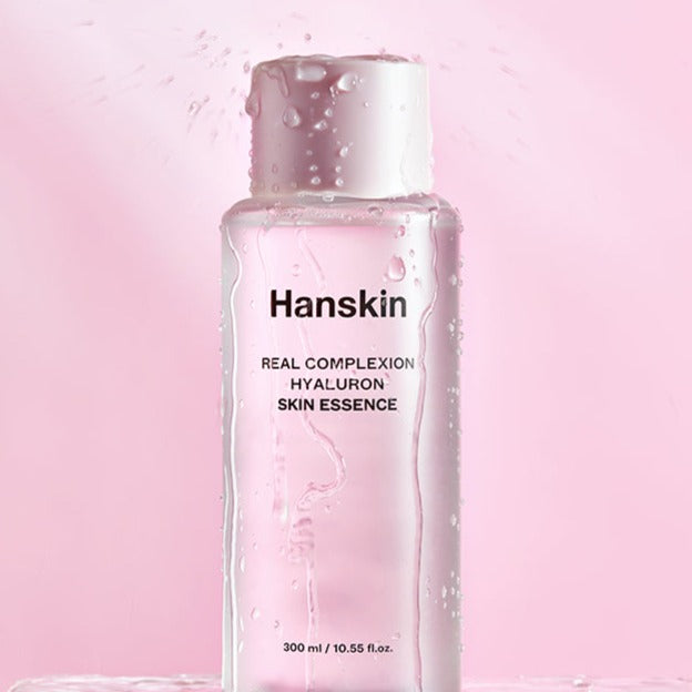 HANSKIN Real Complexion Hyaluron Skin Essence 300ml bottle against a pink background