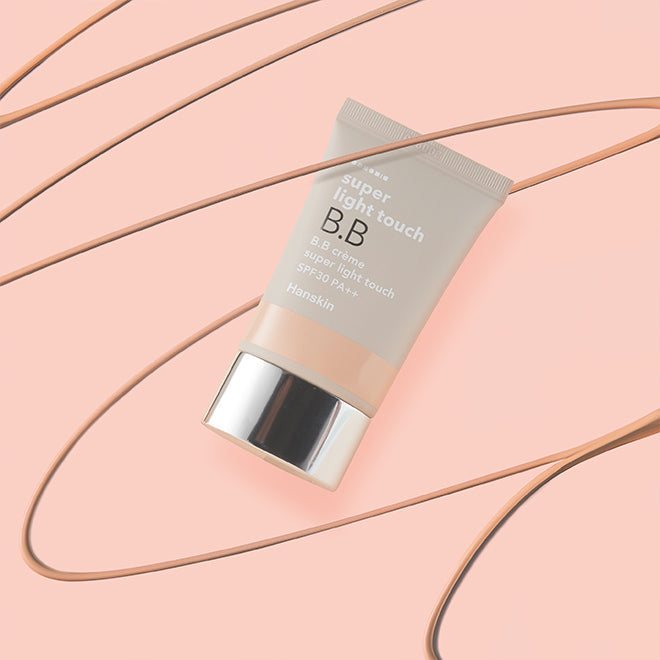 HANSKIN Super Light Touch BB 30g cream on a peach background, highlighting its lightweight, smooth coverage for radiant skin.