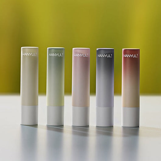 Assorted HANYUL Lip Balm 4g tubes in different shades on a reflective surface
