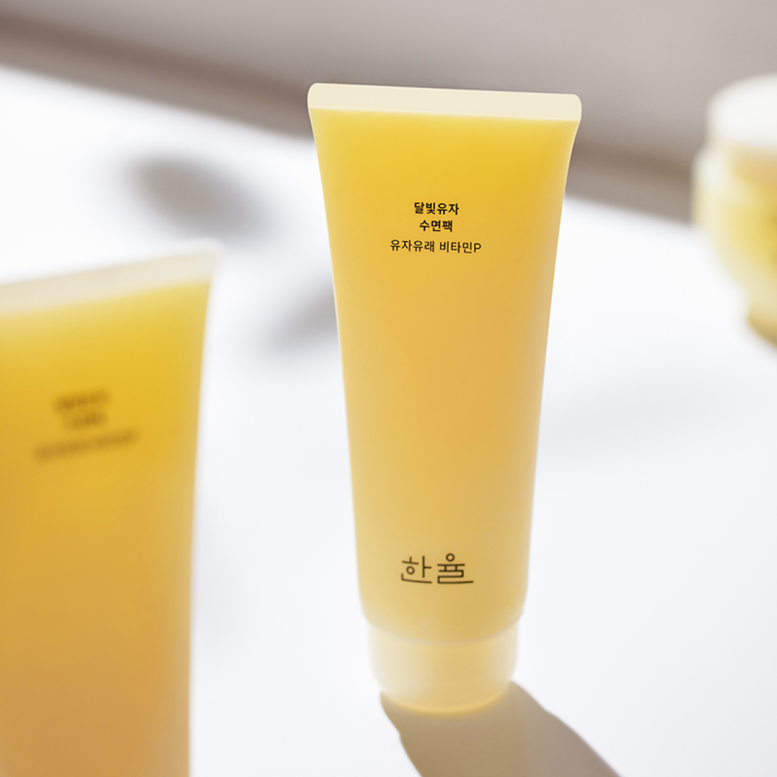 HANYUL Moonlight Yuja Sleeping Pack 100ml in bright yellow packaging against a soft background, showcasing the product.