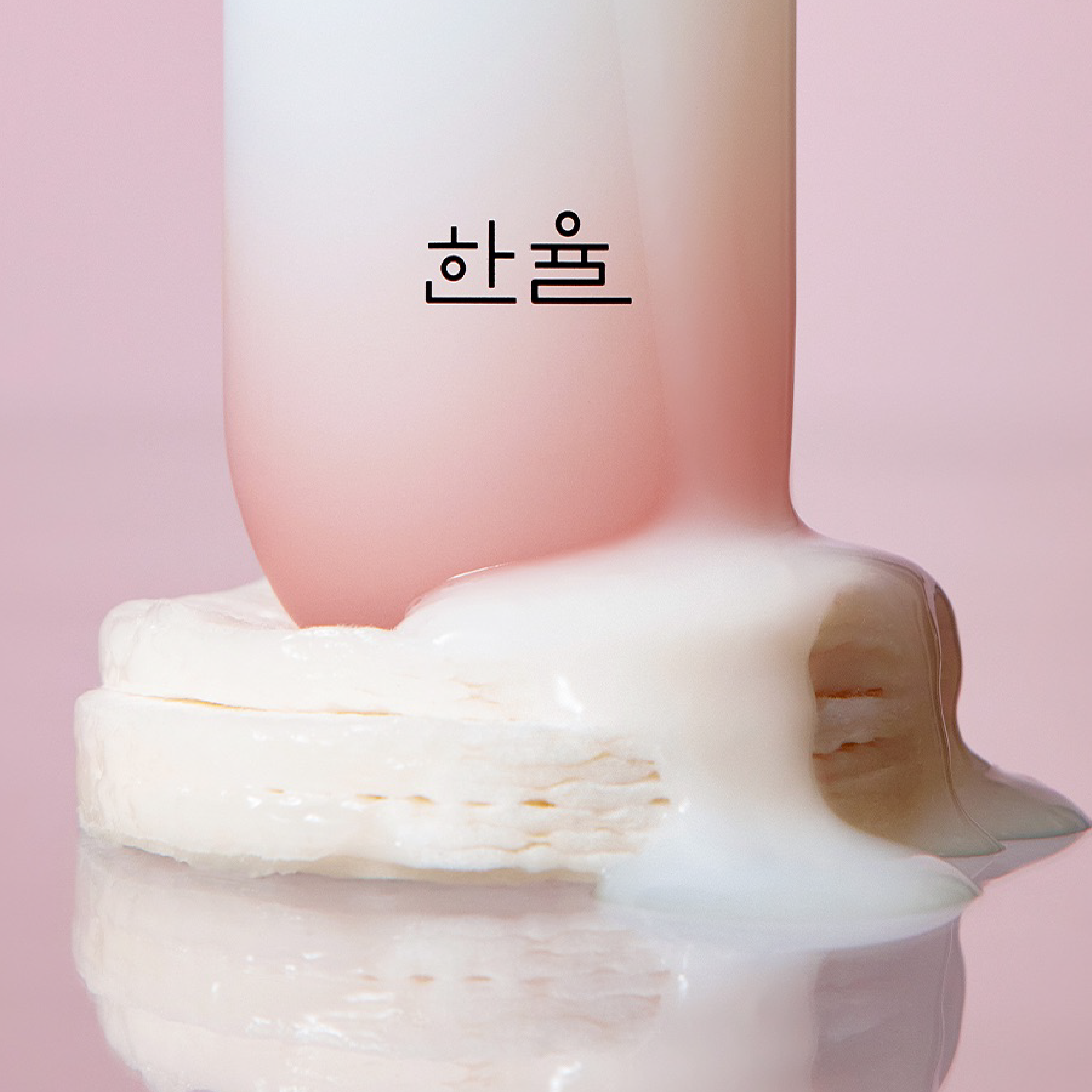 HANYUL Red Rice Moisturizing Elasticity Emulsion bottle with creamy texture on pink background