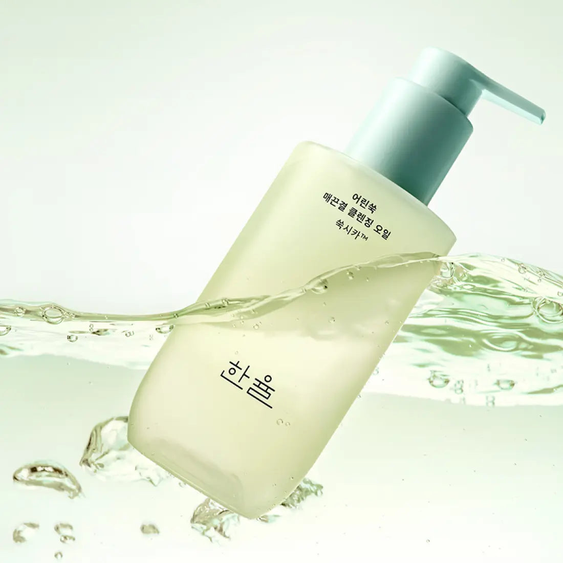 HANYUL Young Artemisia Smooth Cleansing Oil 200ml in a green bottle with a pump, surrounded by swirling oil and bubbles.