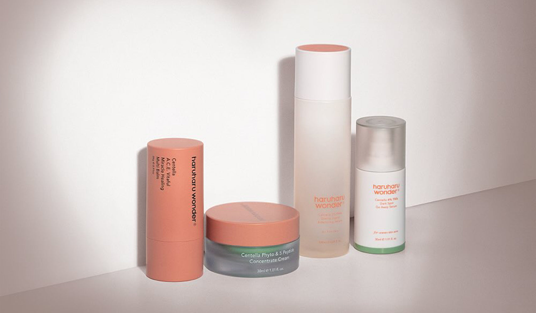 Skincare products with minimalist packaging arranged on a surface, featuring creams and serums in elegant bottles and jars.