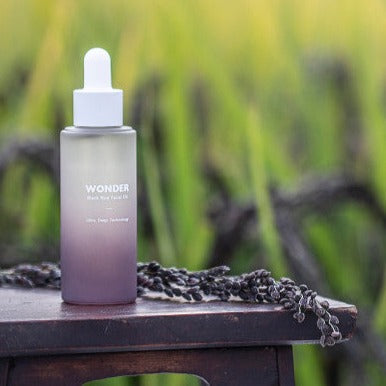 HARUHARU Black Rice Facial Oil 30ml bottle on table with natural background