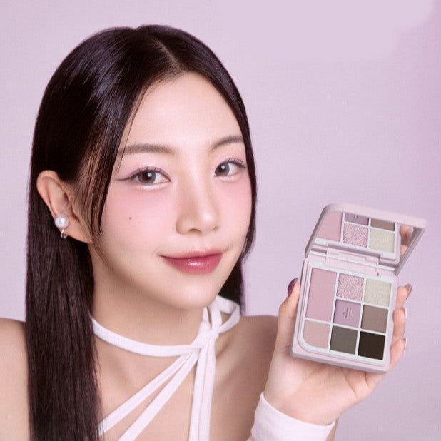 Person holding HEART PERCENT Dot On Mood Eye Palette displaying eyeshadow shades with a mirror.