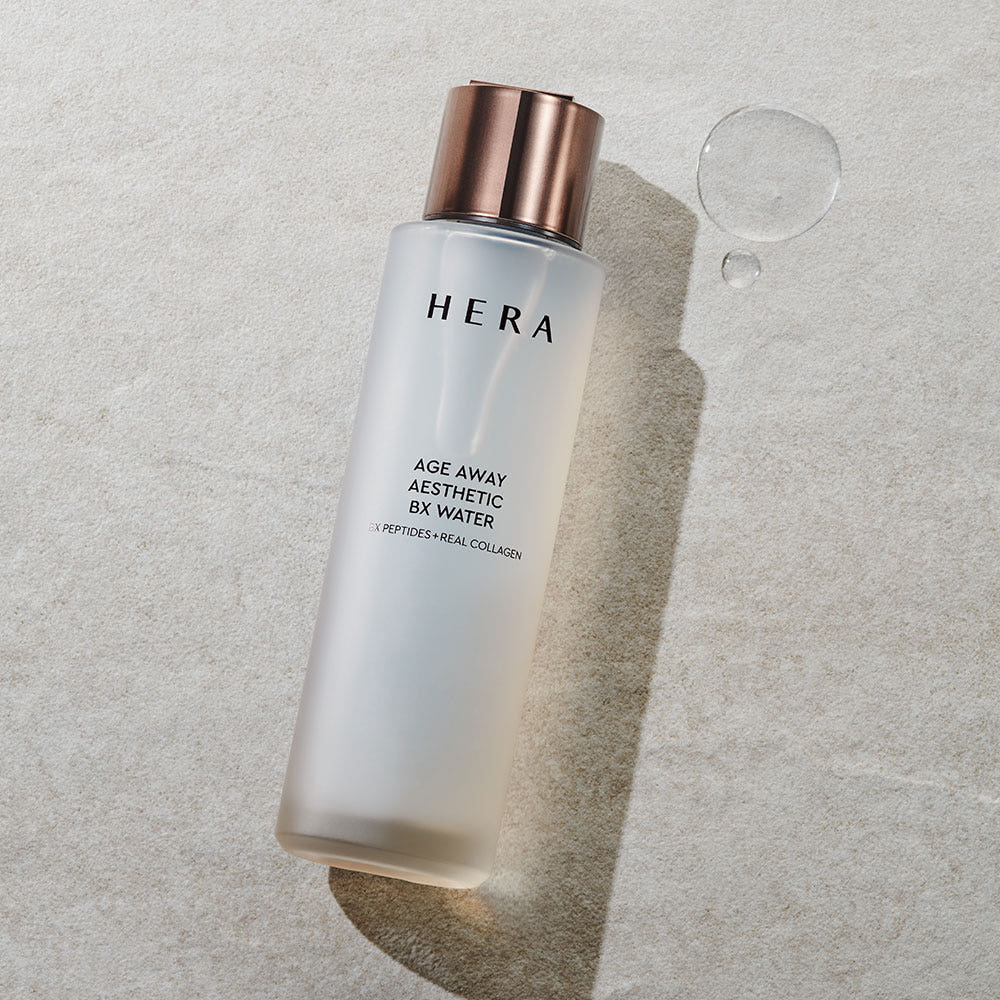 HERA Age Away Aesthetic BX Water 150ml bottle on textured surface with water droplets.