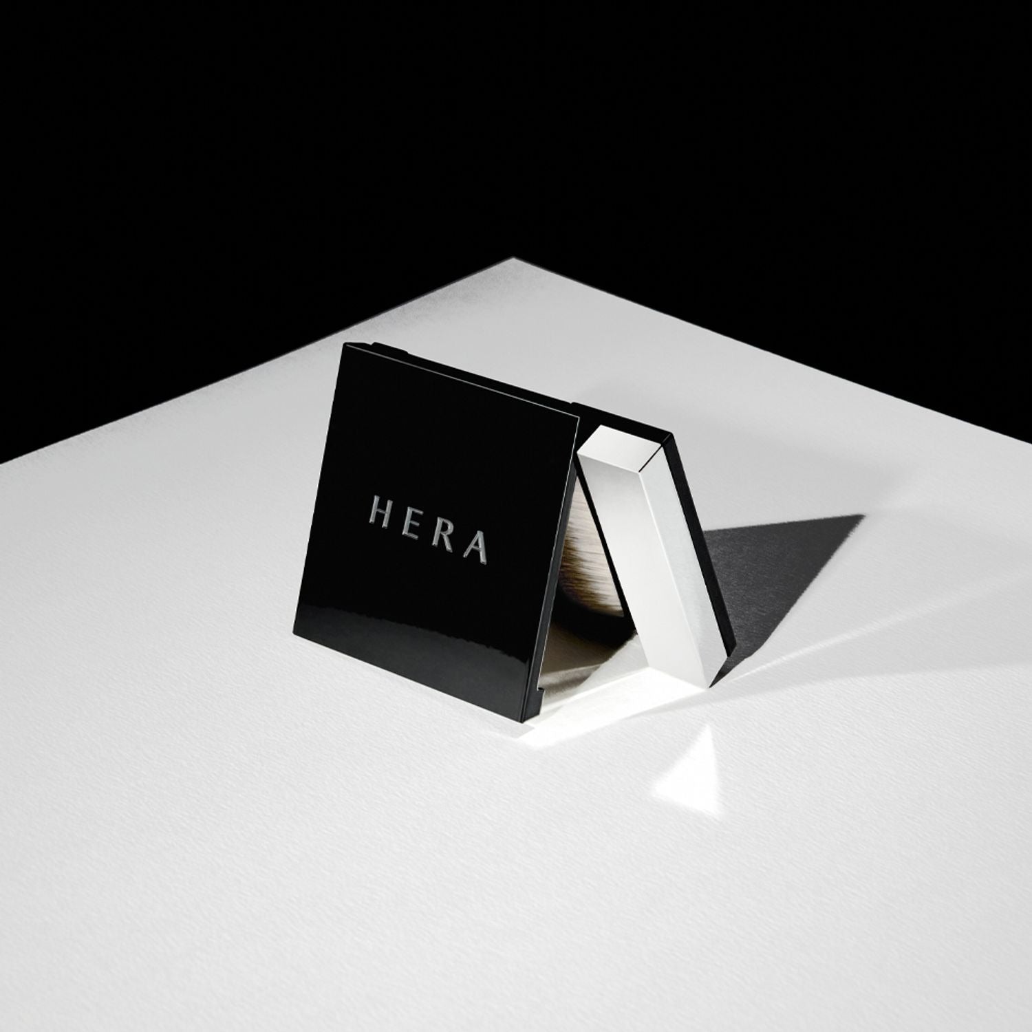 HERA Airy Powder Primer 8.5g compact showcased on a white surface, featuring sleek black packaging ideal for a flawless makeup base.