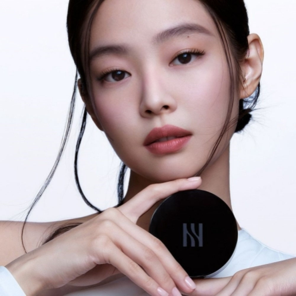 Model holding HERA Black Cushion Foundation SPF34 PA++ 15g showing product packaging.
