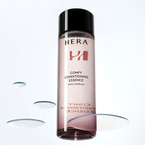 HERA Comfy Conditioning Essence 150g bottle with liquid droplets on white background
