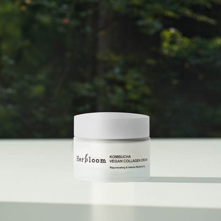 HERBLOOM Kombucha Vegan Collagen Cream 50ml jar on a table with green background.