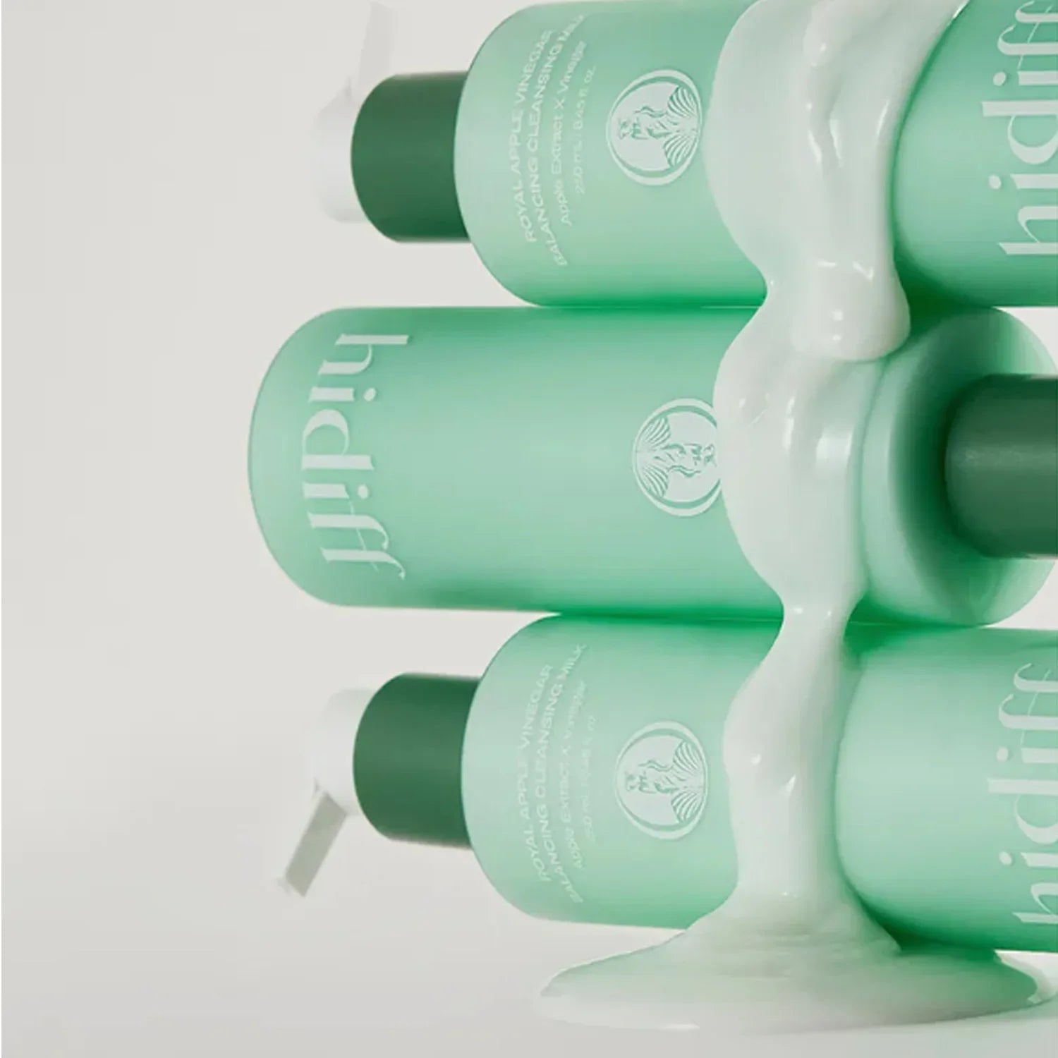 Image of HIDIFF Royal Apple Vinegar Balancing Cleansing Milk 250ml bottles with cleansing milk flowing over.