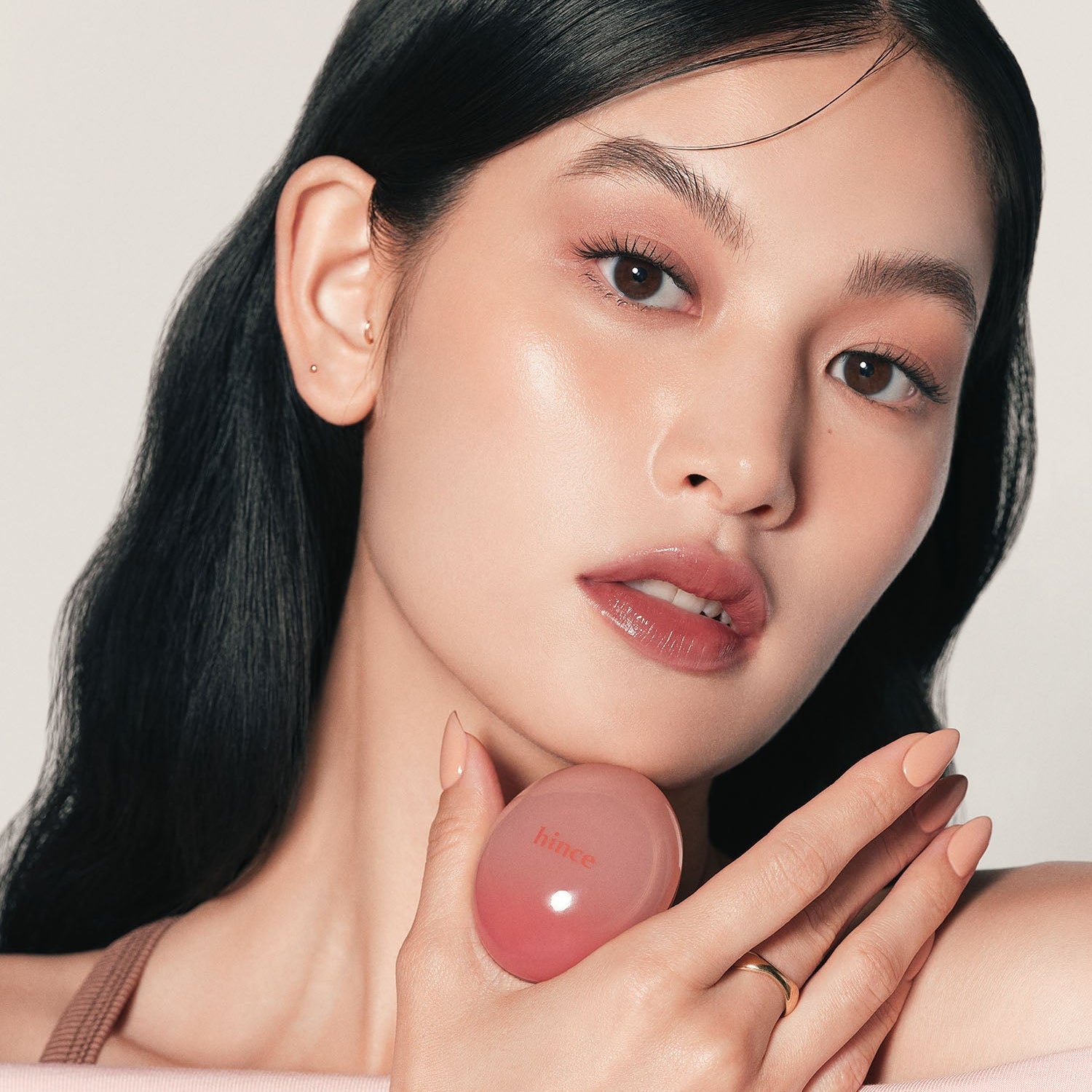 Woman holding HINCE Low Glow Dewy Ball (Lip&Cheek) for a natural makeup look