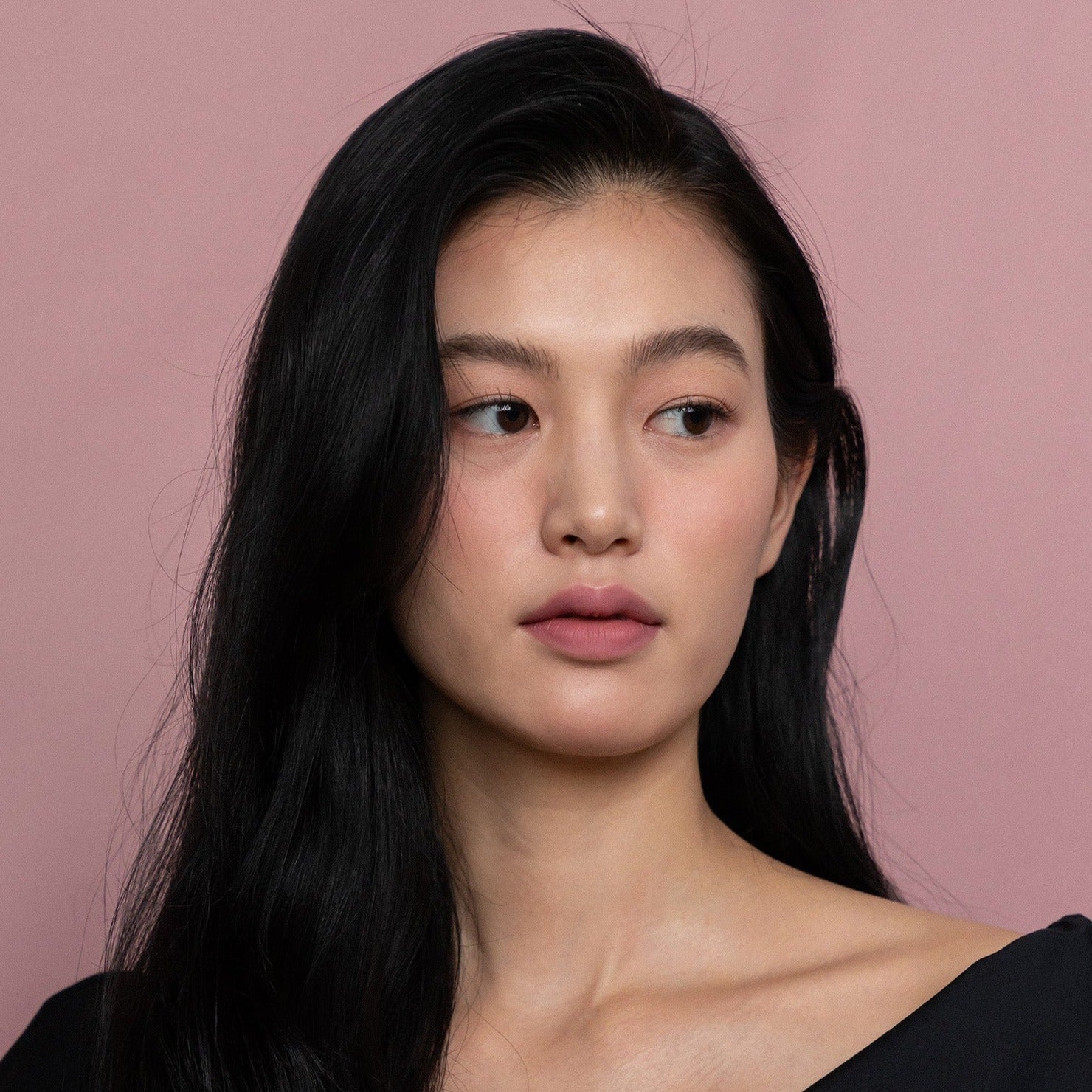 Model wearing HINCE Mood Enhancer Matte lipstick with soft pink background