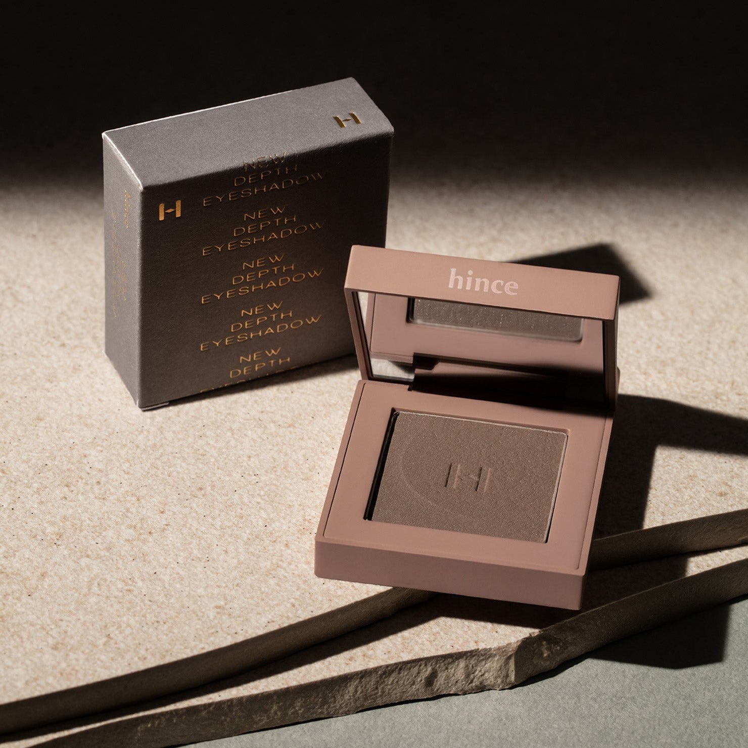 HINCE New Depht Eye Shadow compact and packaging on a textured surface.