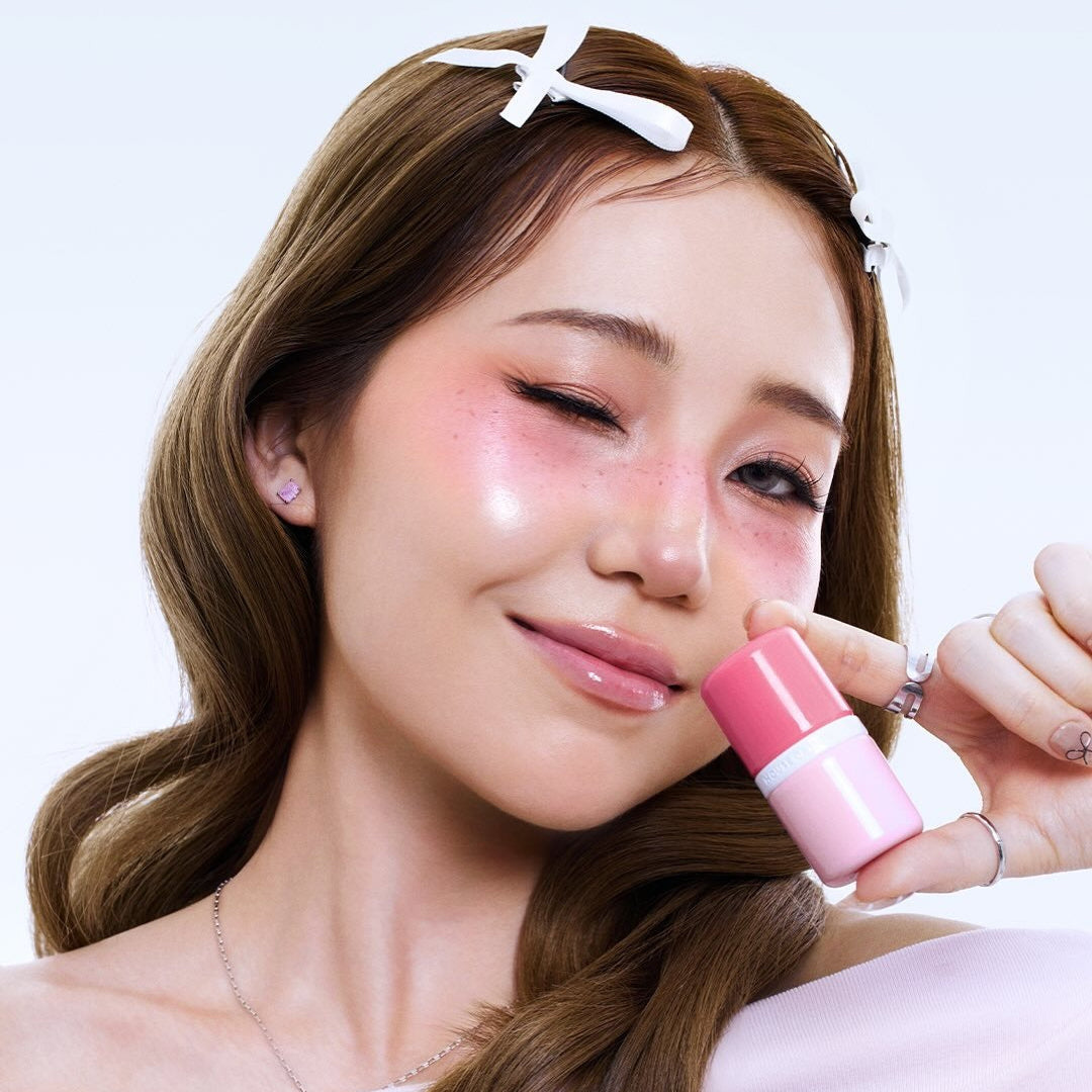 Person holding and showcasing HOUSE OF HUR Every Cheek Blush with a radiant glow, demonstrating the product's color enhancement effect.