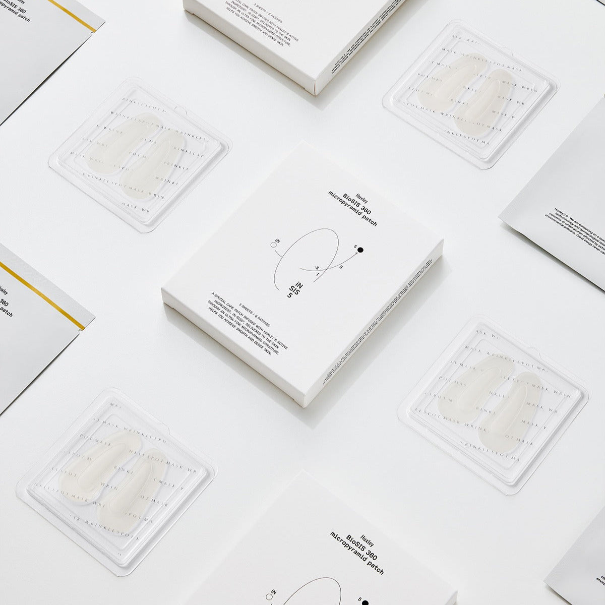 Display of HUXLEY BioSIS 360 Micropyramid Patch packaging and patches on a white background.
