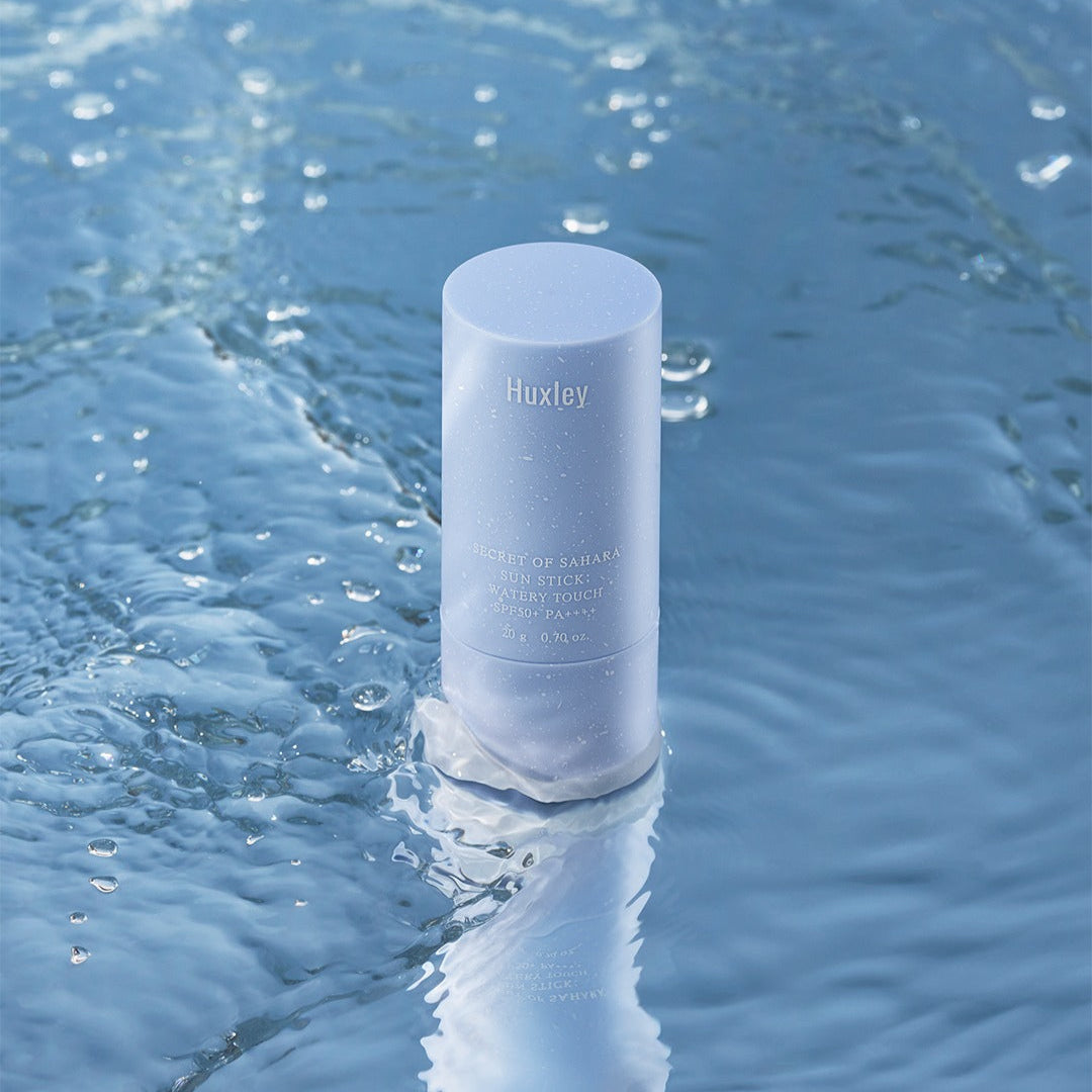 HUXLEY Sun Stick Watery Touch 20g in water, showcasing waterproof sun protection and hydrating benefits in a sleek design.