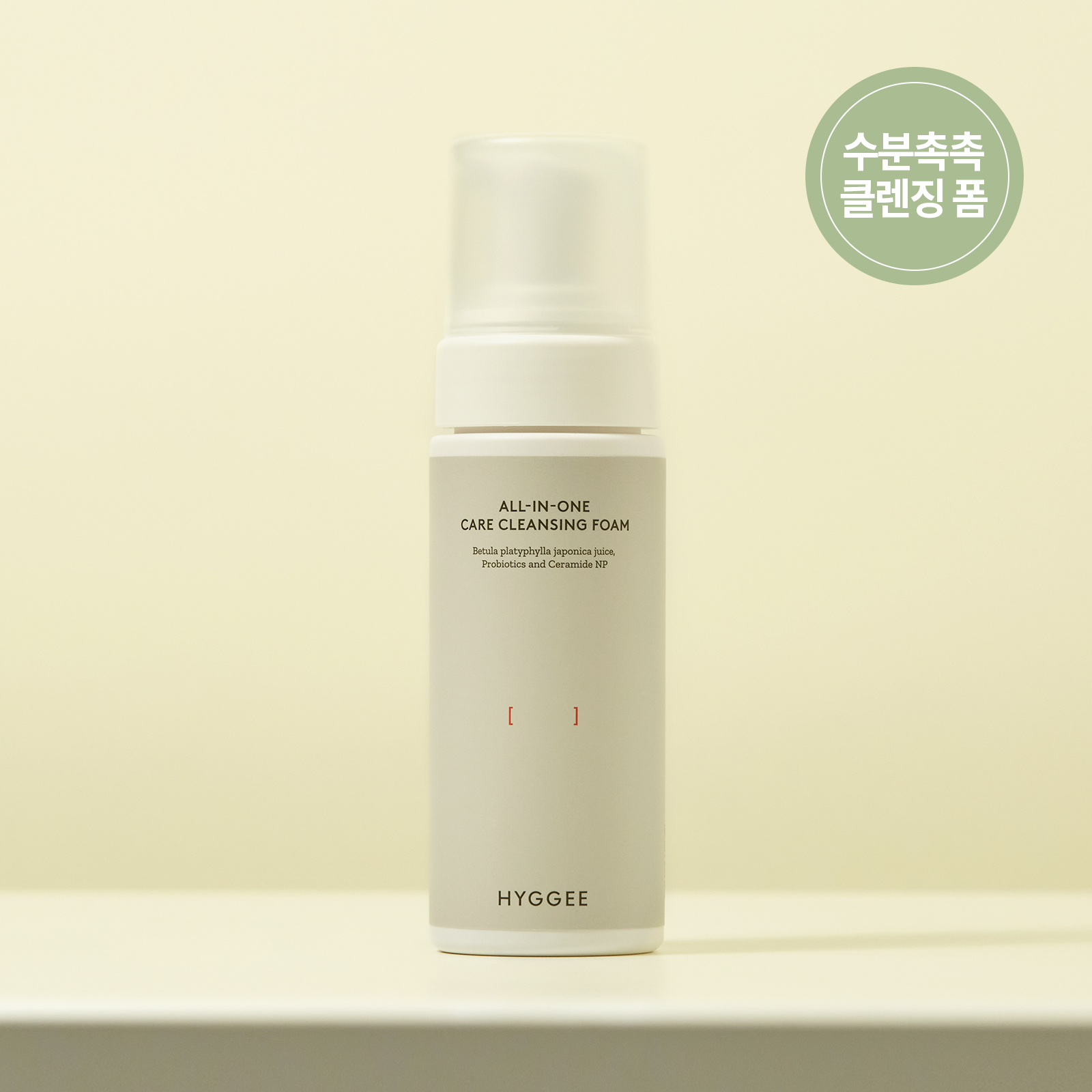 HYGGEE All-In-One Care Cleansing Foam 150ml bottle on a beige background.