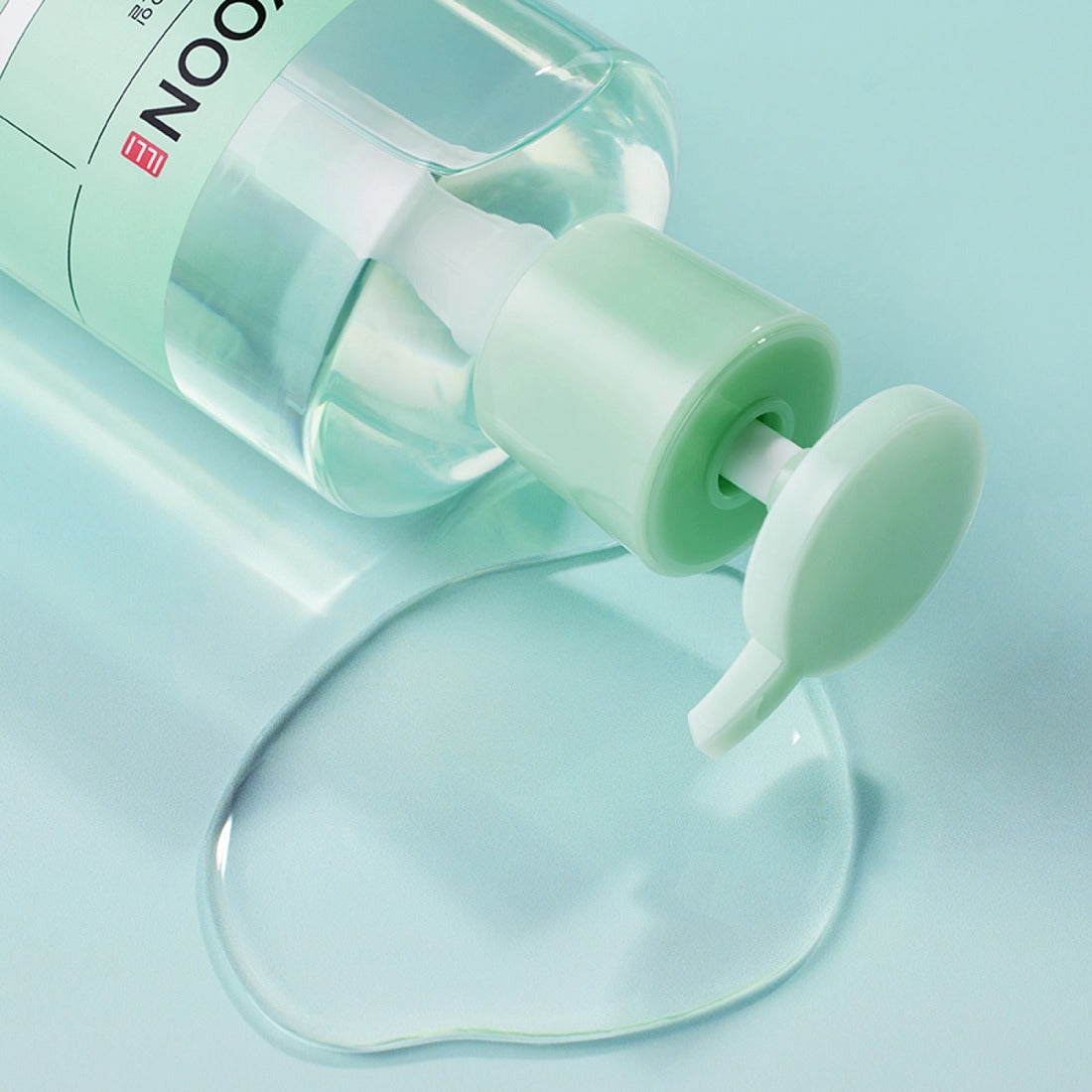 Bottle of ILLIYOON Gentle Deep Cleansing Oil 250ml with oil spill on a blue background
