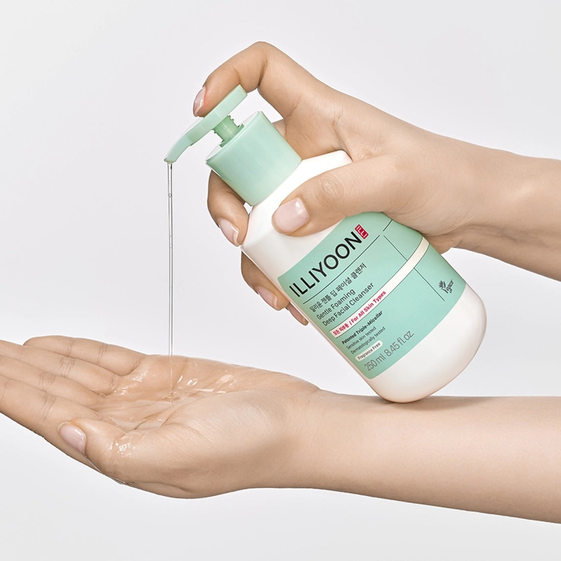 Person using ILLIYOON Gentle Deep Facial Cleanser 250ml, dispensing product into palm for skincare routine.