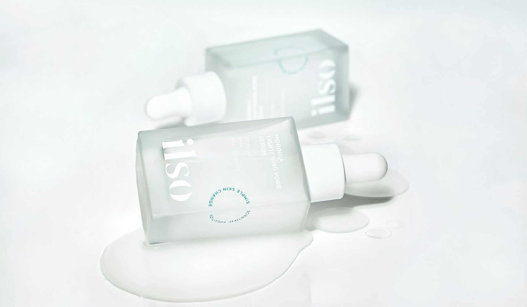 Skincare bottles with white dropper caps lying on a white surface with liquid spills, showcasing a modern and minimalist aesthetic.
