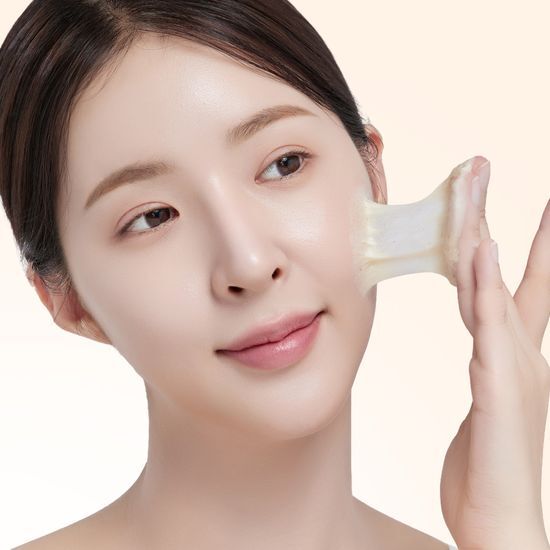 Woman applying ILSO Grain Potato Cleansing Pack Foam 150ml to her face for skincare routine.