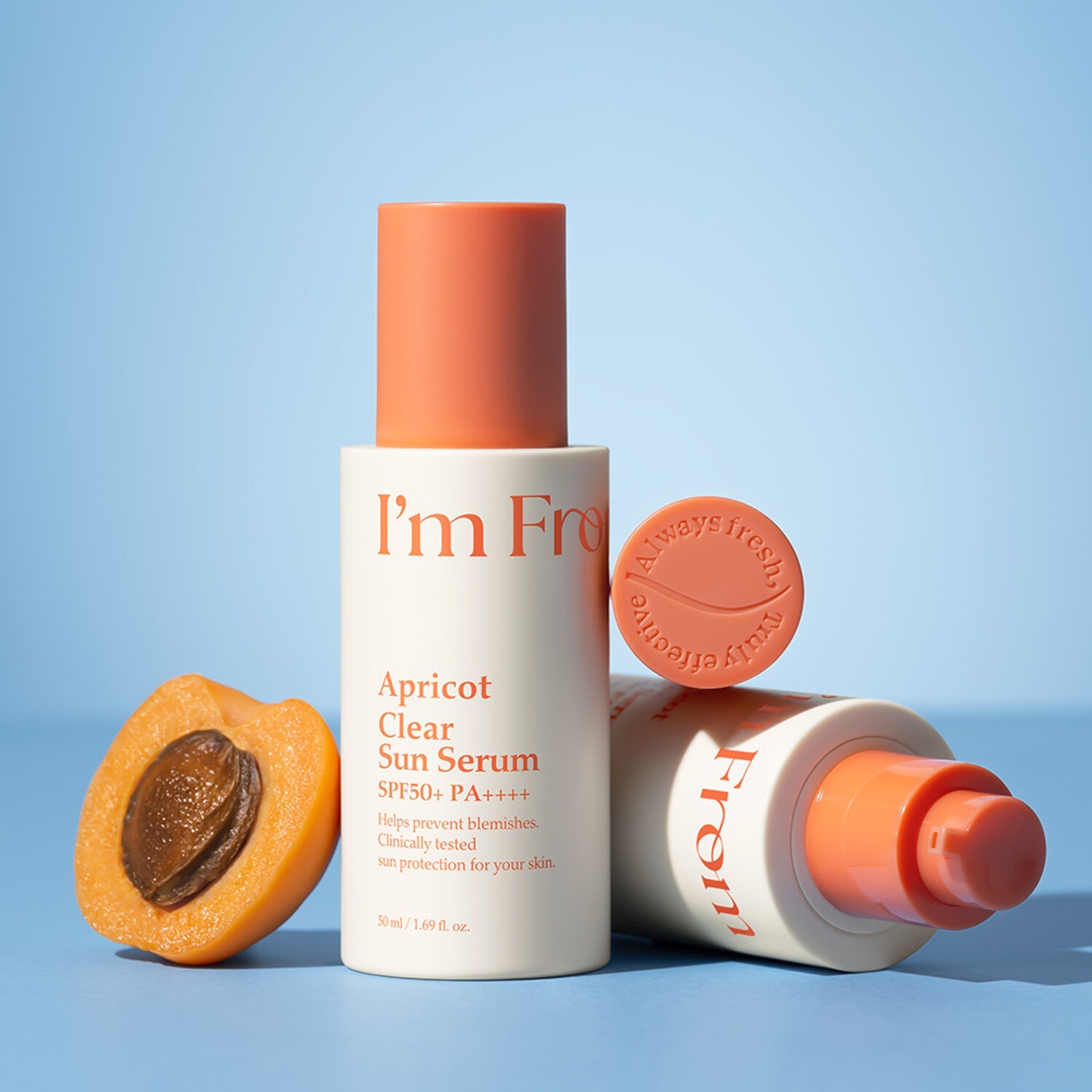 I'M FROM Apricot Clear Sun Serum 50ml with apricot slice and bottle on blue background.