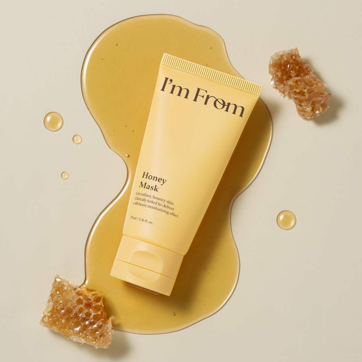 I'M FROM Honey Mask 70ml in yellow tube surrounded by honeycomb and honey on beige background, skincare product for nourishing skin.