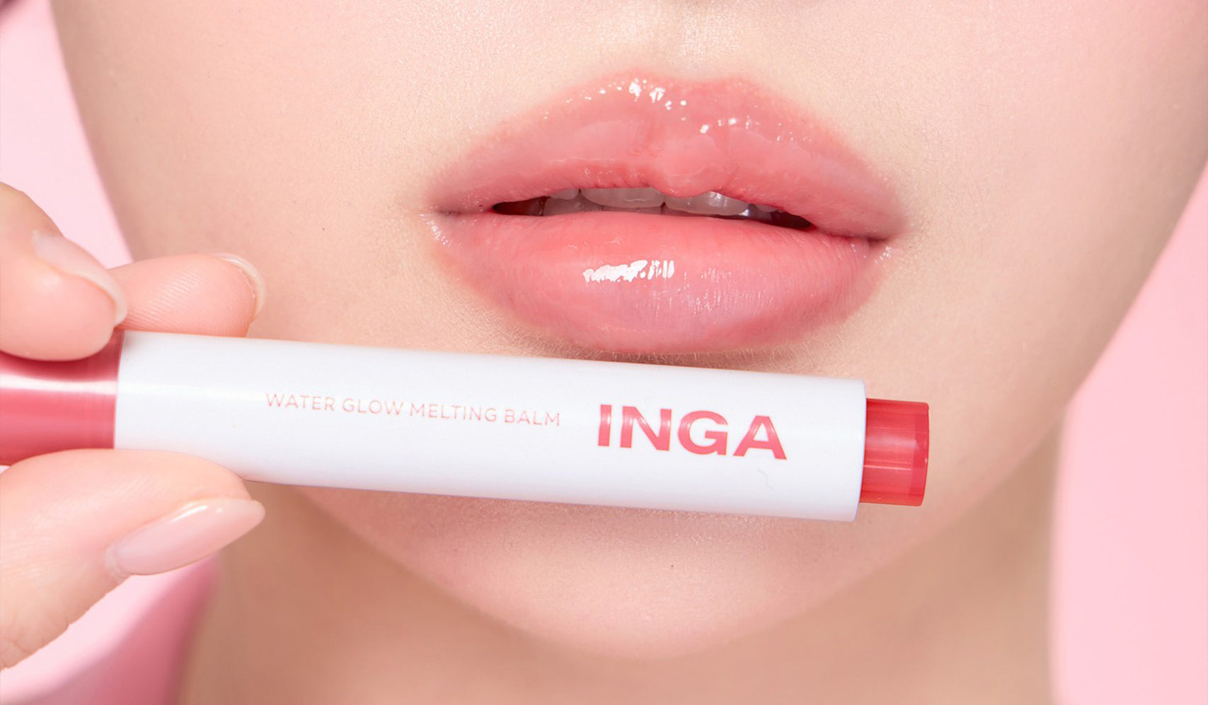Close-up of glossy lips with INGA Water Glow Melting Balm in pink tube.