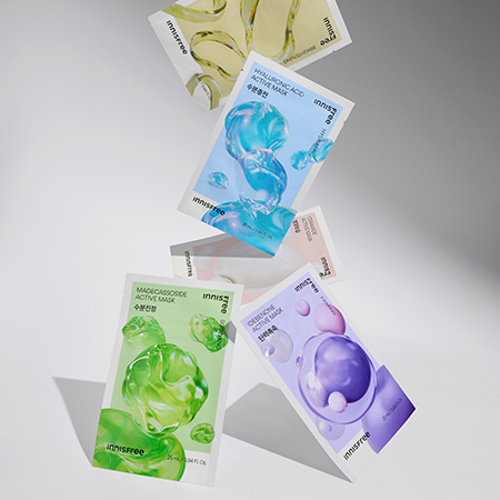 Various INNISFREE Active Mask packs floating against a gradient background, showcasing vibrant colors and textures.