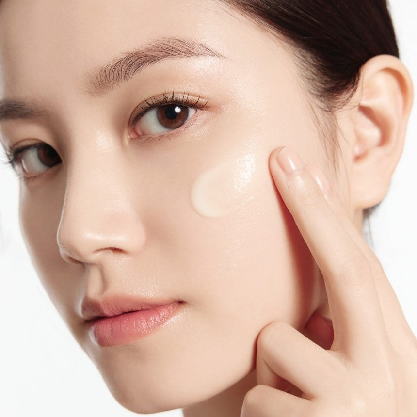 Woman applying IOPE Retinol Expert 0.1% Wrinkle Corrector 30ml Set on cheek for anti-aging skincare