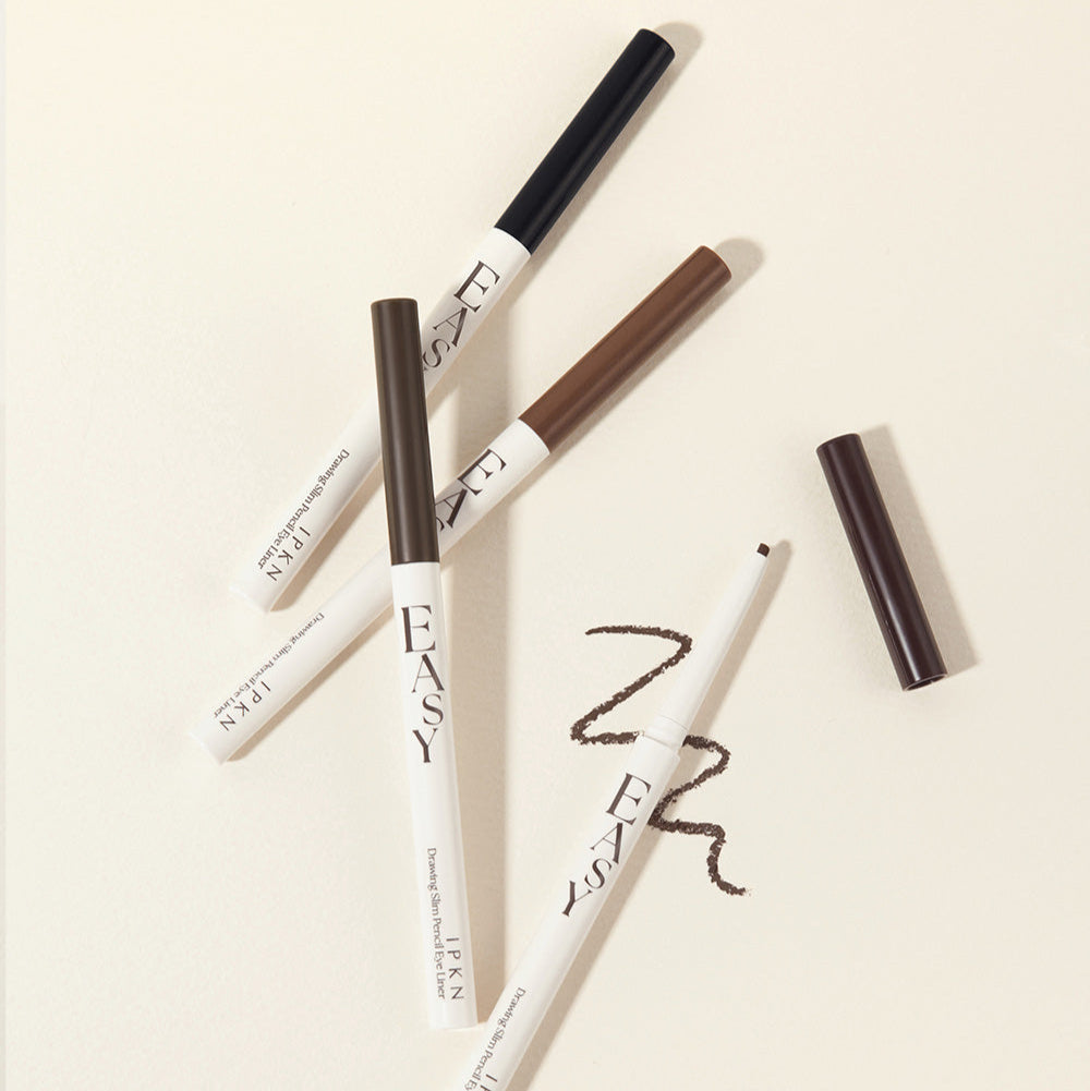 Assorted shades of IPKN Easy Drawing Slim Pencil Eyeliner on a beige background.