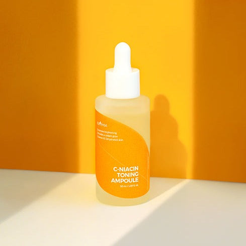 ISNTREE C-Niacin Toning Ampoule 50ml bottle on an orange background