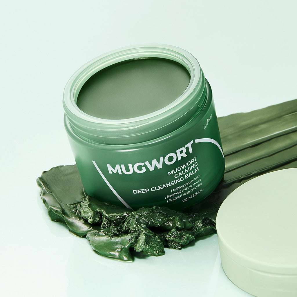 ISNTREE Mugwort Calming Deep Cleansing Balm 100g in open jar with green balm, displayed on a background with leaves.