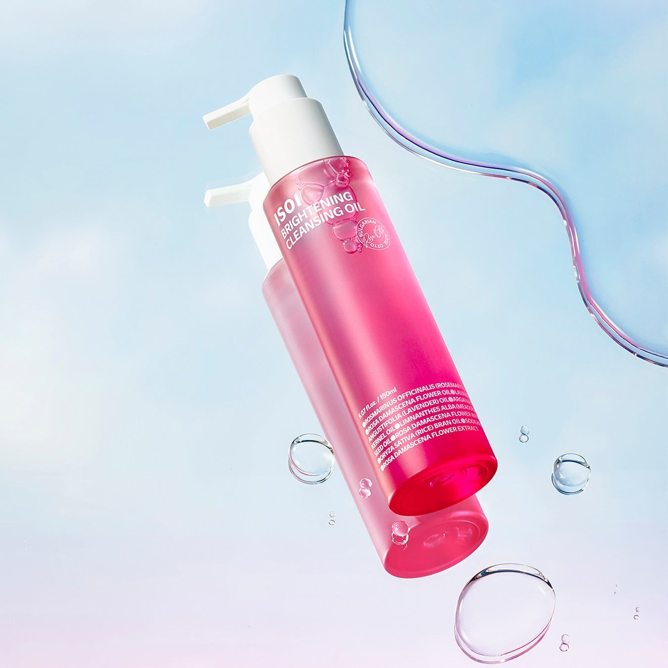 ISOI Brightening Cleansing Oil 150ml bottle with pink liquid, displayed with water droplets on a light blue background for skincare.