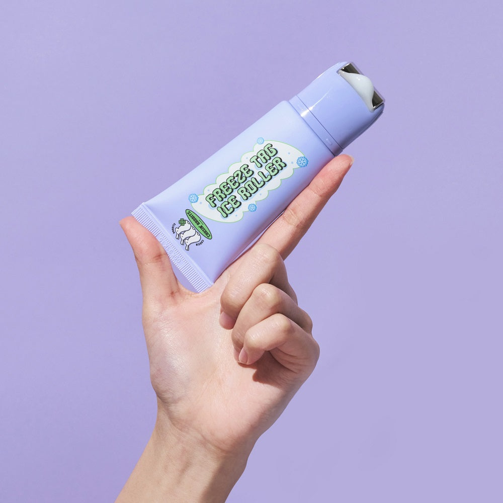 Hand holding IT'S SKIN Freeze Tag Ice Roller against purple background
