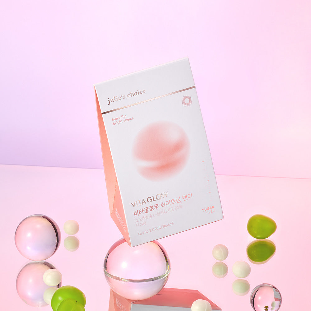 JULIE'S CHOICE Vita Glow Whitening Candy pink box with candies around on a reflective surface