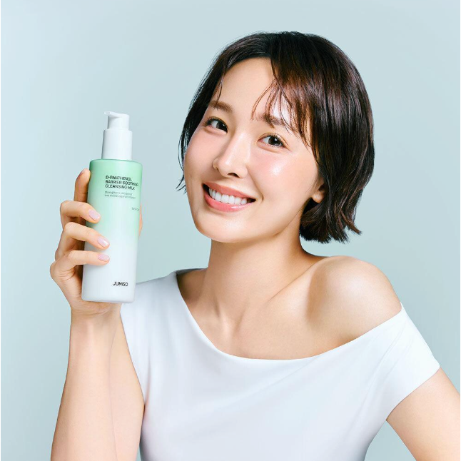 Person holding JUMISO D-Panthenol Barrier Soothing Cleansing Milk 300ml Refill Offer (+100ml Refill) in a smiling pose