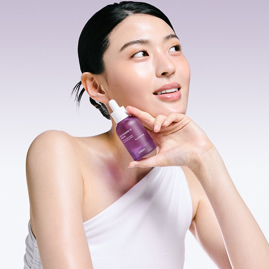Woman holding JUMISO Niacinamide 10 Serum 40ml with a smile.