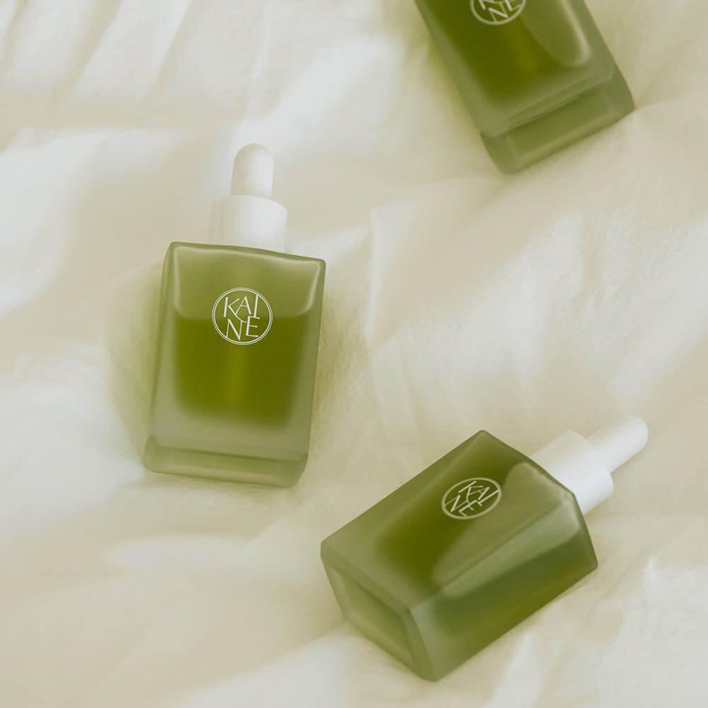 KAINE Rosemary AHA Night Serum 30ml bottles displayed on a soft fabric background, highlighting the product design and green packaging.