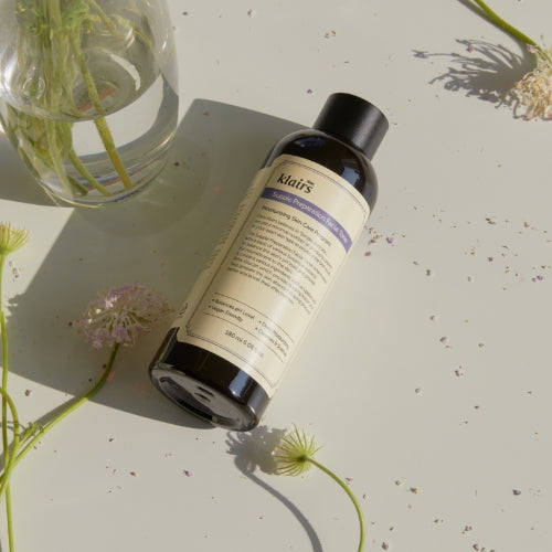 KLAIRS Supple Preparation Facial Toner 180ml bottle on a light background with flowers