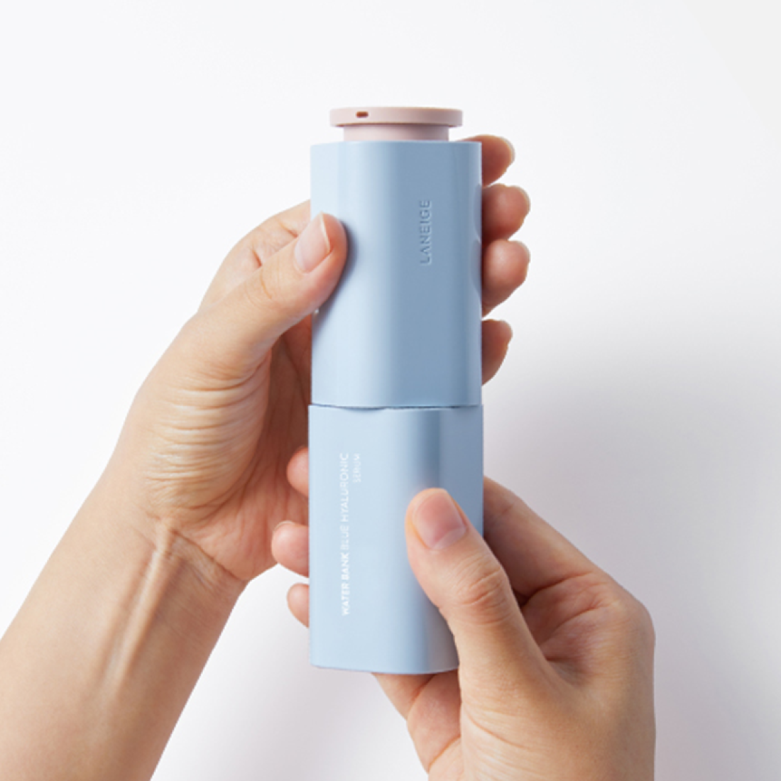 Hands holding LANEIGE Water Bank Blue Hyaluronic Serum 50ml bottle